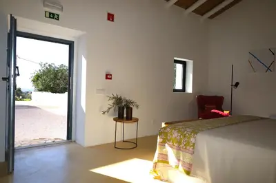 a bedroom with a bed and a sliding glass door at Uma Casa Rural in Santa Bárbara de Nexe