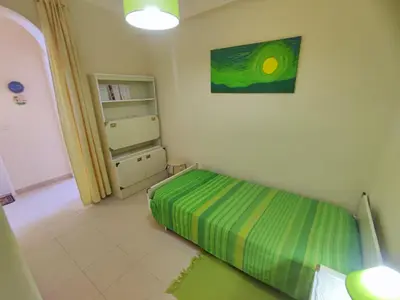 a small bedroom with a bed and a book shelf at Algarve, cozy T1plus1 apartment in the centre of Quarteira in Quarteira