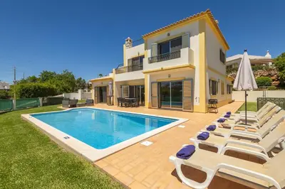 a villa with a swimming pool and lounge chairs at Villa Joana by Villa Select in Albufeira