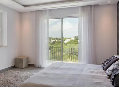 a bedroom with a bed and a large window at Stunning home with nice pool close to the beach in Loulé