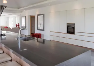 a kitchen with a sink and a living room at Stunning home with nice pool close to the beach in Loulé