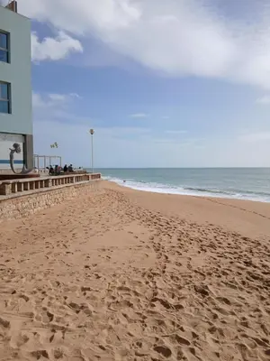 a sandy beach with a building and the ocean at Casa Donis 2021 in Albufeira