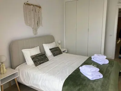 a bedroom with a white bed with towels on it at Apartamento T2 Moderno no Centro de Faro - ML - Market Tower in Faro