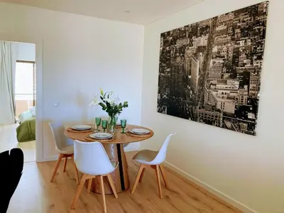 a dining room with a table and white chairs at Apartamento T2 Moderno no Centro de Faro - ML - Market Tower in Faro