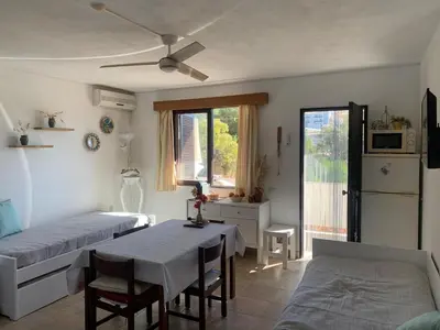 a room with two beds and a table and a window at Casa Oura Praia located 100 metres from the beach in Albufeira