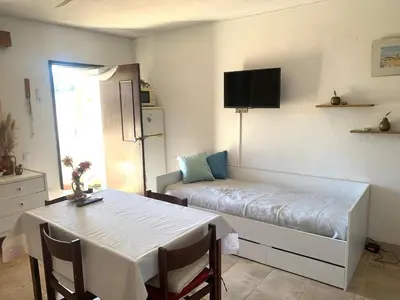 a room with a bed and a table and a bed and a window at Casa Oura Praia located 100 metres from the beach in Albufeira