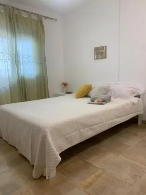 a large white bed with a blanket on it at Casa Oura Praia located 100 metres from the beach in Albufeira