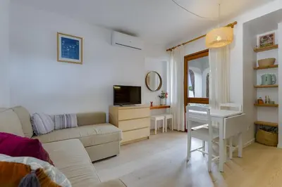 a living room with a couch and a table and a desk at AÇOTEIAS BEACH STUDIO - 5 min to Falesia Beach in Albufeira