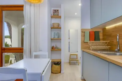 a kitchen with a table and a white refrigerator at AÇOTEIAS BEACH STUDIO - 5 min to Falesia Beach in Albufeira