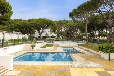 a swimming pool with trees in the background at AÇOTEIAS BEACH STUDIO - 5 min to Falesia Beach in Albufeira