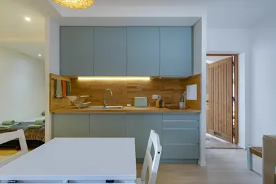 a kitchen with blue cabinets and a table at AÇOTEIAS BEACH STUDIO - 5 min to Falesia Beach in Albufeira