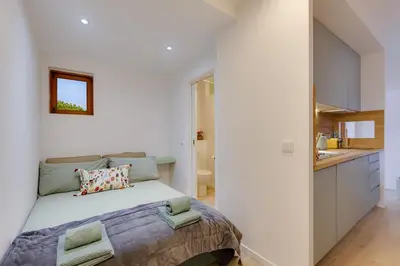 a bedroom with a bed and a small kitchen at AÇOTEIAS BEACH STUDIO - 5 min to Falesia Beach in Albufeira
