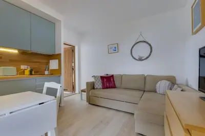 a living room with a couch and a kitchen at AÇOTEIAS BEACH STUDIO - 5 min to Falesia Beach in Albufeira