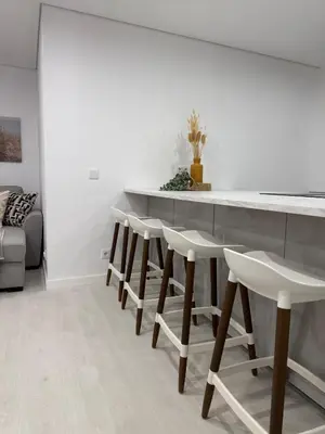 a kitchen with a row of stools around a counter at Sunrise Apartment in Albufeira