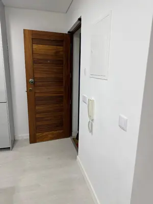 a hallway with a wooden door and a phone at Sunrise Apartment in Albufeira