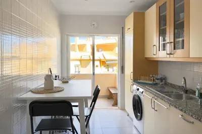 a kitchen with a sink and a washing machine at Apartamento Terraços do Vale in Albufeira
