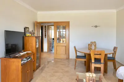 a living room with a table and a dining room at Apartamento Terraços do Vale in Albufeira