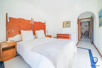 a bedroom with a large white bed with a wooden headboard at Balaia Mar 63A by MTPhomes in Albufeira