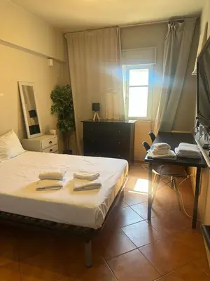 a bedroom with a bed and a table and a desk at Beach Holiday House T1 in Quarteira