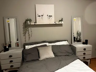a bedroom with a bed and two mirrors at Beach Holiday House T1 in Quarteira