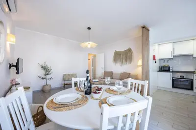 a kitchen and dining room with a white table and chairs at Albufeira City Centre Apartment with Pool in Albufeira