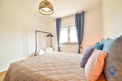 a bedroom with a bed with blue curtains and a window at Eva Andorinha 5 Pax by MTPhomes in Albufeira