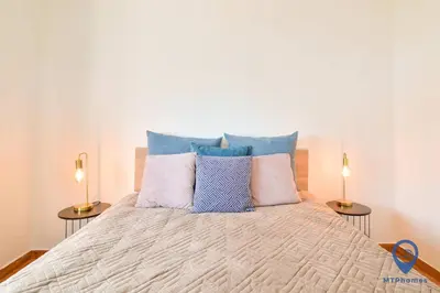 a bedroom with a bed with two side tables at Eva Andorinha 5 Pax by MTPhomes in Albufeira