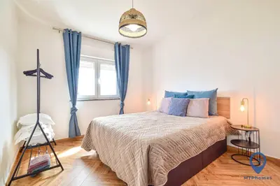 a bedroom with a large bed with blue curtains at Eva Andorinha 5 Pax by MTPhomes in Albufeira