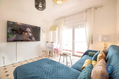 a living room with a blue couch and a tv at Eva Andorinha 5 Pax by MTPhomes in Albufeira