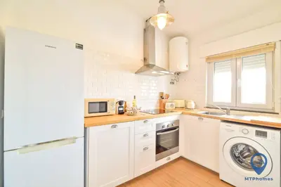 a kitchen with white cabinets and a washer and dryer at Eva Andorinha 2 Pax by MTPhomes in Ferreiras