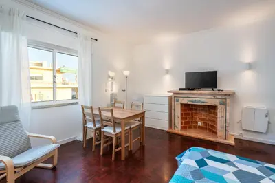 a living room with a dining room table and a fireplace at Blife Faya private apartment in FAO
