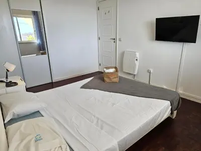a bedroom with a large bed with a bag on it at Blife Faya private apartment in FAO