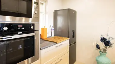 a kitchen with a stainless steel refrigerator and a counter at Apart Palmeira Galé - Sea view - WIFI - BY BEDZY in Guia