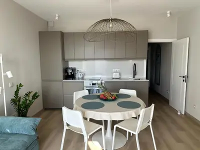 a kitchen and living room with a table and a couch at BnB Homes Ocean Breeze Terrace Apartment 400 m away from the Ocean in Albufeira