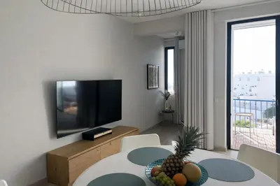 a living room with a television and a table with fruit on it at BnB Homes Ocean Breeze Terrace Apartment 400 m away from the Ocean in Albufeira