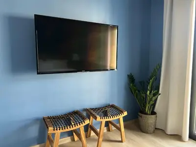 a tv on a blue wall with a shopping cart at BnB Homes Ocean Breeze Terrace Apartment 400 m away from the Ocean in Albufeira