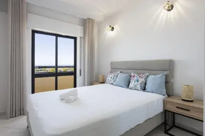 a bedroom with a large white bed with a window at Dunas - Sea view near the beach by HD in Quarteira