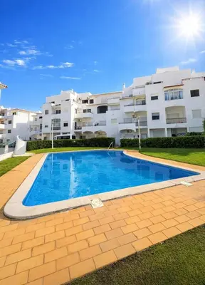 a swimming pool in front of a large building at Majesti Algarve Apartment in Albufeira