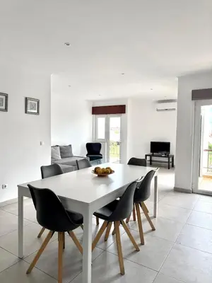 a white table and chairs in a living room at Majesti Algarve Apartment in Albufeira