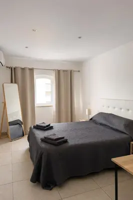 a bedroom with a bed with two towels on it at Majesti Algarve Apartment in Albufeira