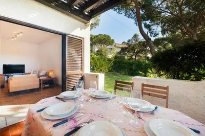 a table with plates and wine glasses on a patio at Cozy Villa next to the Golf Course by Algarve Dream Holidays in Quarteira