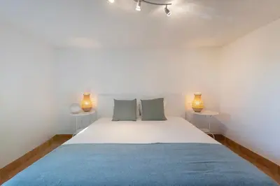 a bedroom with a large white bed with two tables at Cozy Villa next to the Golf Course by Algarve Dream Holidays in Quarteira