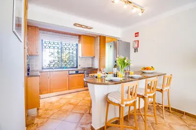 a kitchen with a large island with bar stools at Duplex Apartment with Pool, Balcony, Wi-Fi & AC in Vilamoura