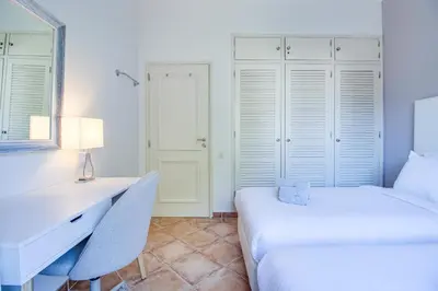 a bedroom with two beds and a desk and a mirror at Duplex Apartment with Pool, Balcony, Wi-Fi & AC in Vilamoura