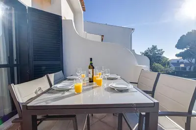a table with a bottle of wine and glasses at Duplex Apartment with Pool, Balcony, Wi-Fi & AC in Vilamoura