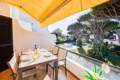 a dining room with a table and chairs and a balcony at Duplex Apartment with Pool, Balcony, Wi-Fi & AC in Vilamoura