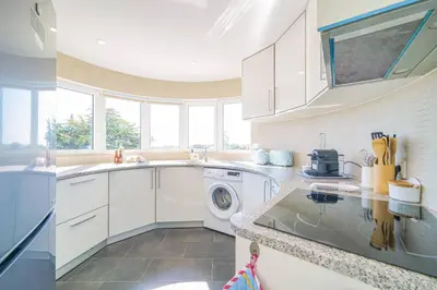 a kitchen with white cabinets and a washer and dryer at Coral by MTPhomes in Albufeira
