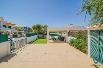 a patio with a table and chairs and a house at Casa Joana by MTPhomes in Albufeira