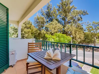 a book sitting on a wooden table on a balcony at Apartamento Mélias, 2 quartos e piscina, Vilamoura in Vilamoura