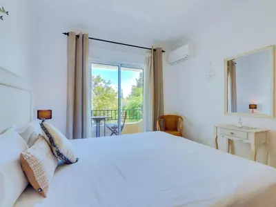 a bedroom with a white bed and a window at Apartamento Mélias, 2 quartos e piscina, Vilamoura in Vilamoura